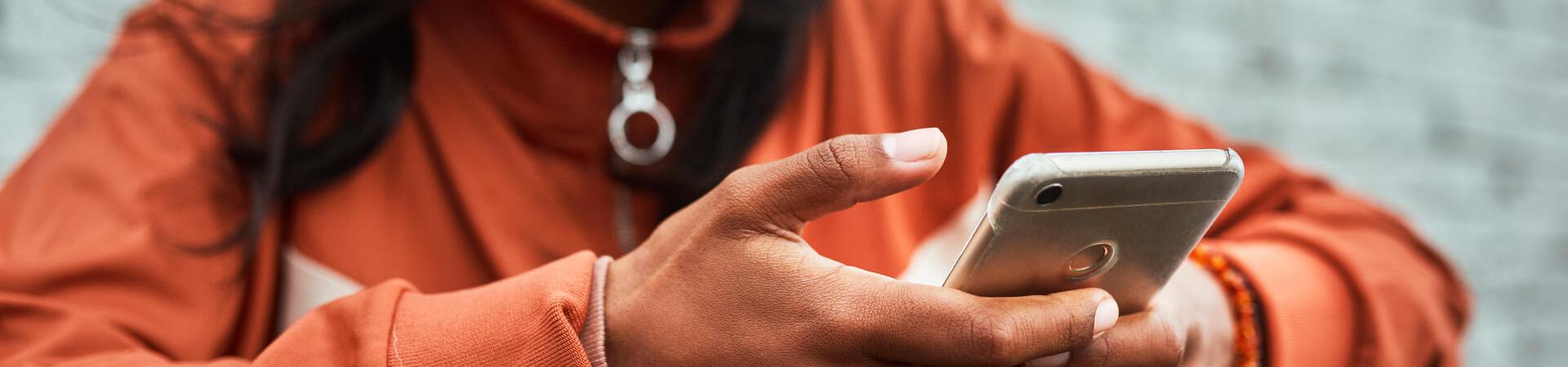 Eine Person nutzt unterwegs ein Smartphone