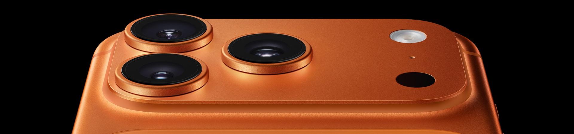Nahaufnahme der Rückseite eines orangefarbenen iPhone 17 Pro Max mit drei großen Kameralinsen, Blitz und Sensor auf schwarzem Hintergrund