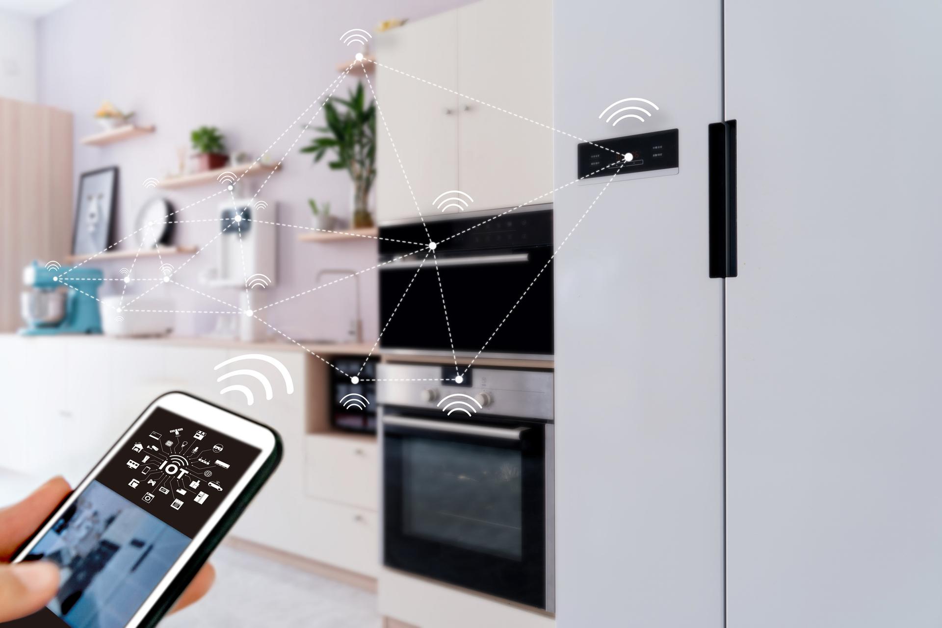 Smart-Home-Küche mit vernetzten Geräten wie Kühlschrank und Backofen, die per Smartphone gesteuert werden