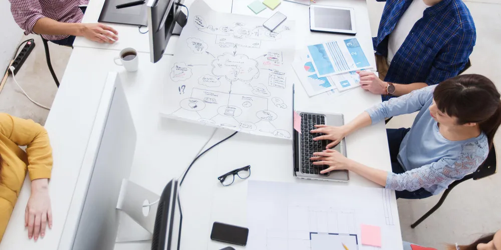 Team arbeitet gemeinsam im Büro an digitalen Anwendungen und Projekten