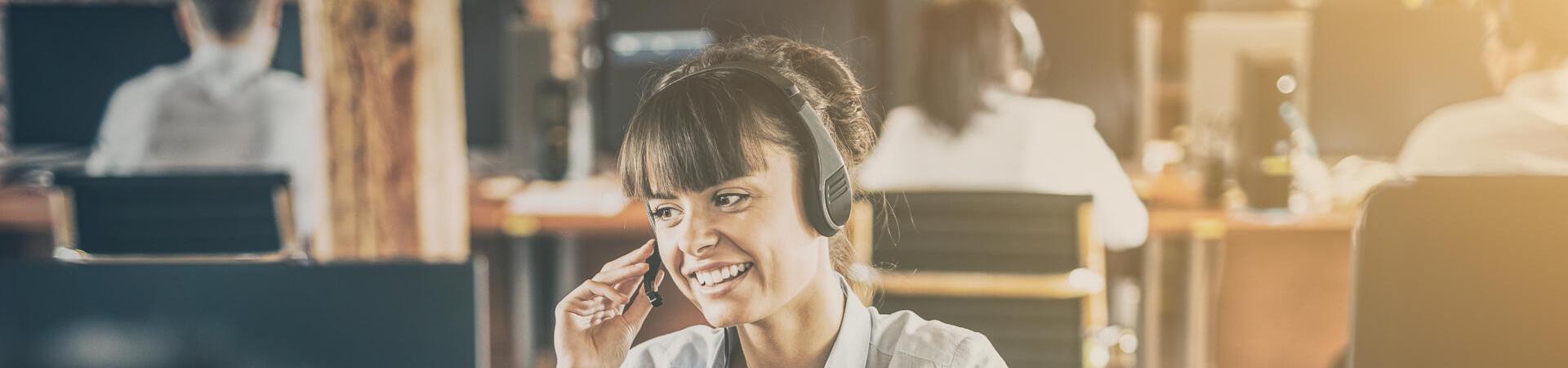 Mitarbeiterin im Kundenservice telefoniert mit Headset