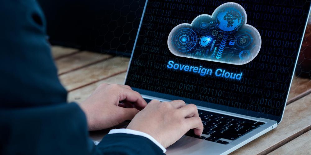 Ein aufgeklappter Laptop, auf dessen Bildschirm „Sovereign Cloud“ steht; jemand tippt auf der Tastatur