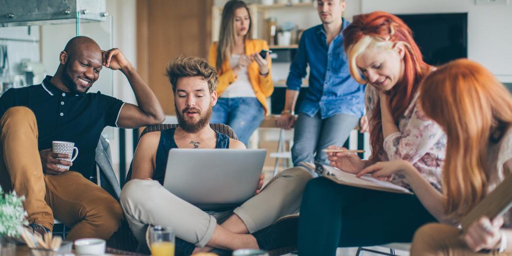 Junge Leute arbeiten und diskutieren gemeinsam im Wohnzimmer