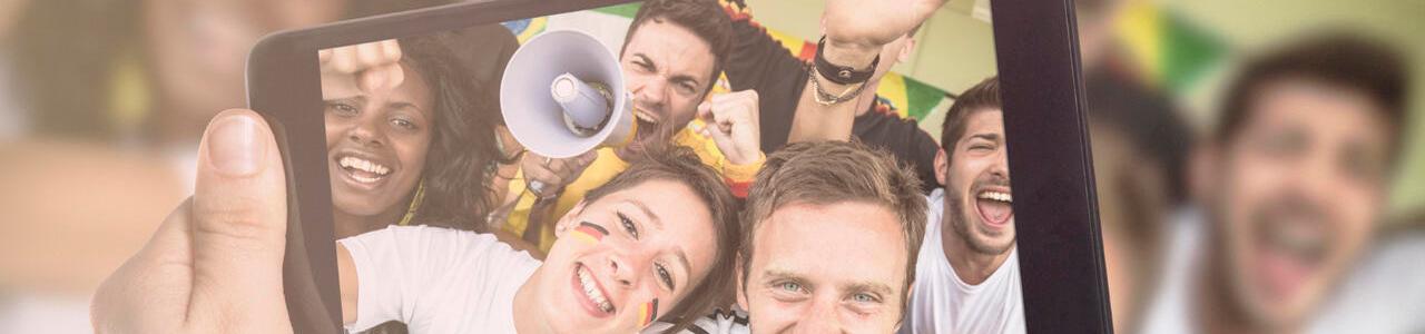 Jubelnde Fußballfans machen ein Selfie mit einem Tablet