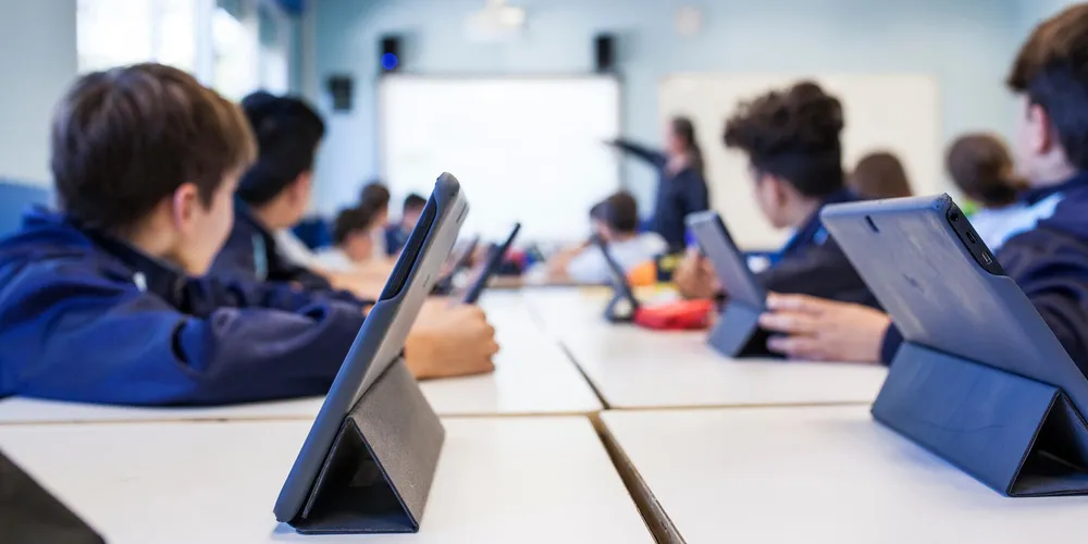 Schülerinnen und Schüler arbeiten mit Tablets im Klassenzimmer