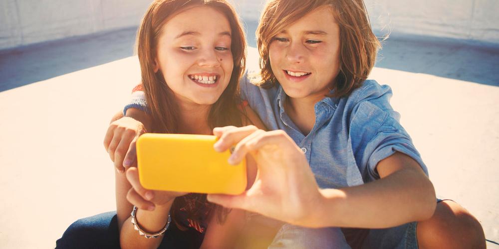 Zwei Kinder machen ein Selfie mit einem Smartphone