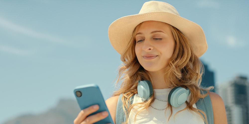 Eine Person guckt lächelnd auf ihr Smartphone 