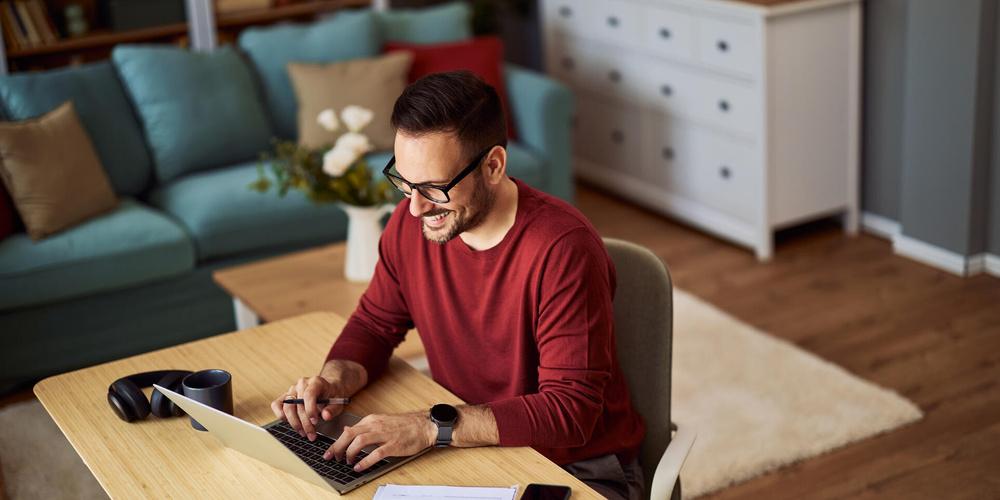 Mann konfiguriert zu Hause am Laptop einen WLAN-Repeater für eine bessere Internetverbindung
