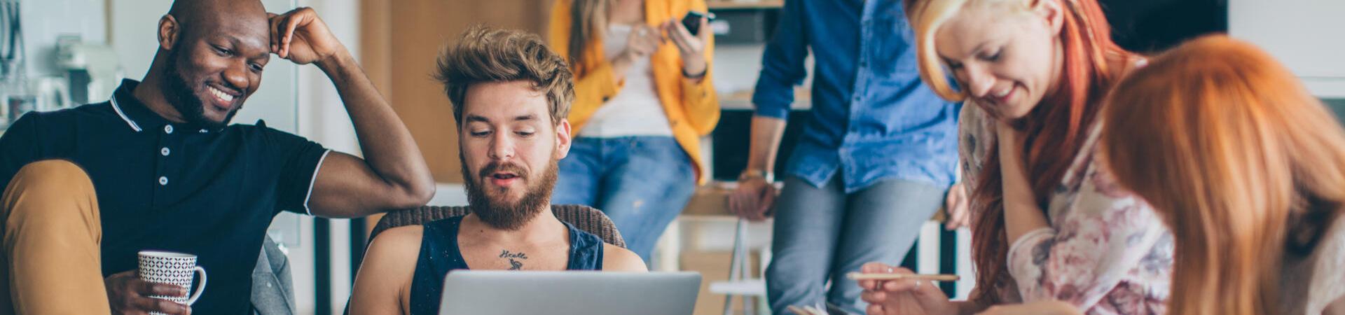 Junge Leute arbeiten und diskutieren gemeinsam im Wohnzimmer