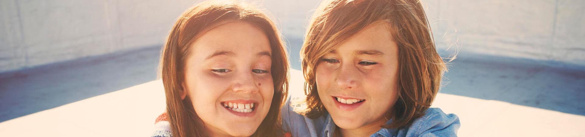 Zwei Kinder machen ein Selfie mit einem Smartphone