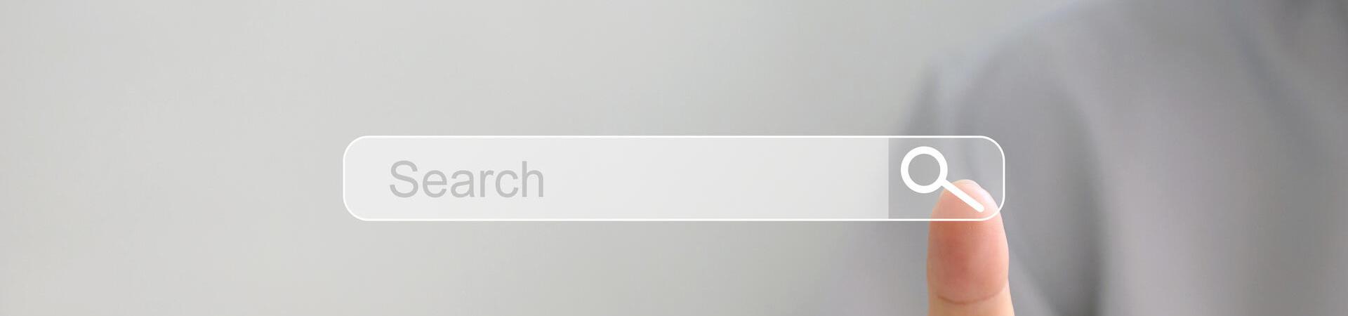 Finger tippt auf ein digitales Suchfeld mit Lupensymbol