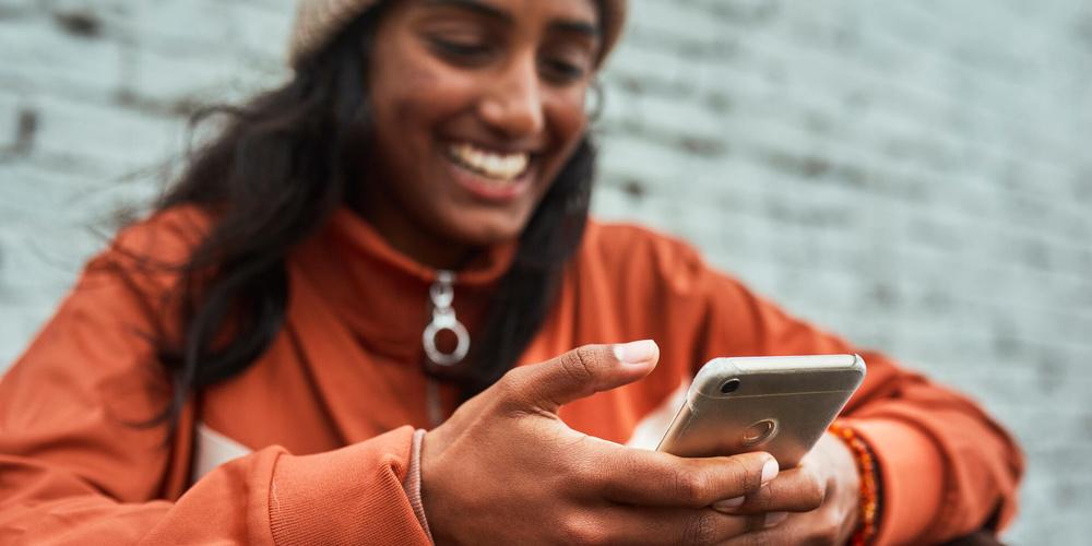 Eine Person nutzt unterwegs ein Smartphone