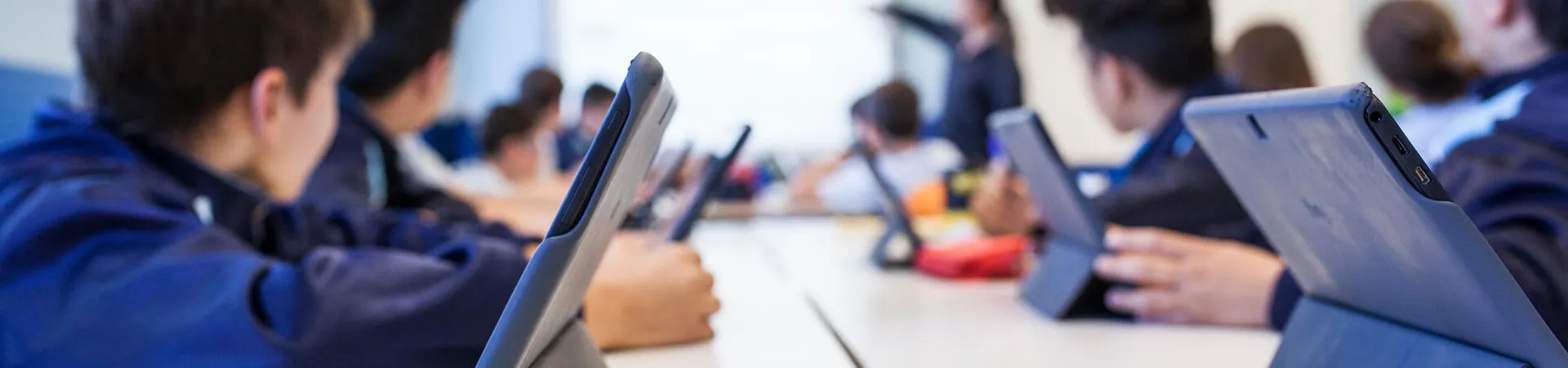 Schülerinnen und Schüler arbeiten mit Tablets im Klassenzimmer