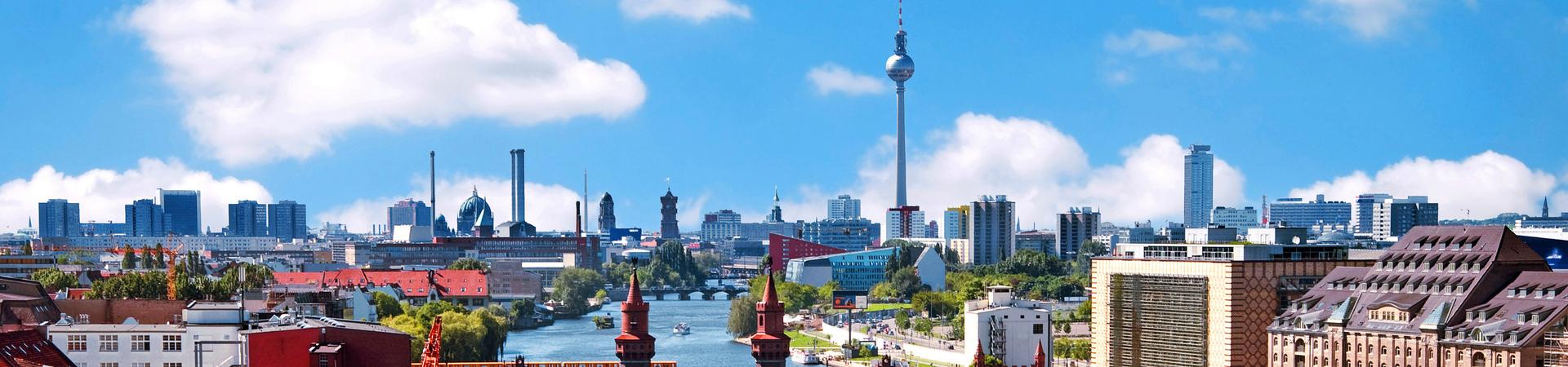 Stadtansicht von Berlin mit Oberbaumbrücke, Spree und Fernsehturm bei blauem Himmel.