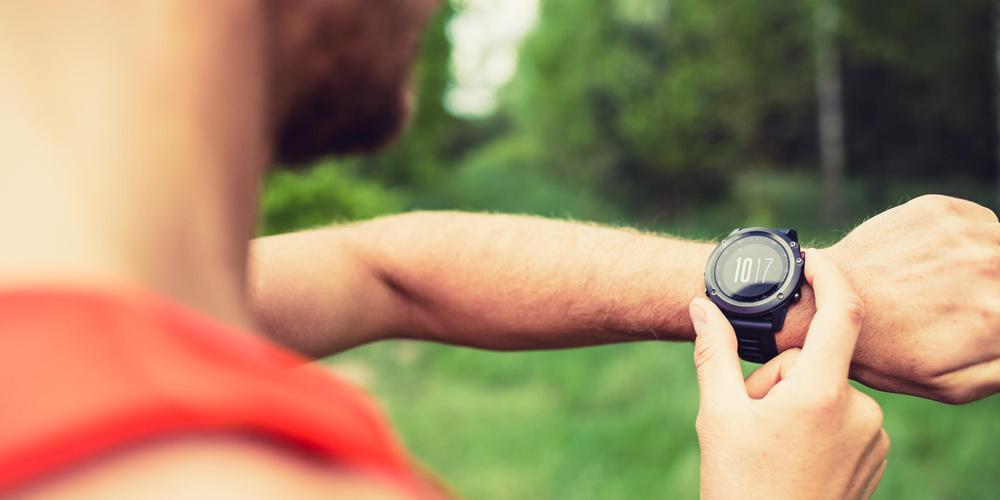 Eine Person startet beim Lauftraining eine Aufzeichnung auf ihrer Smartwatch