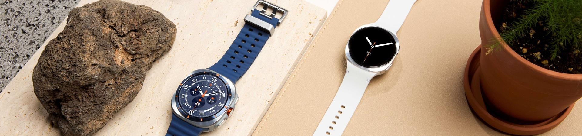 Drei Samsung Galaxy Watch8 Modelle liegen neben Steinen und einer Pflanze