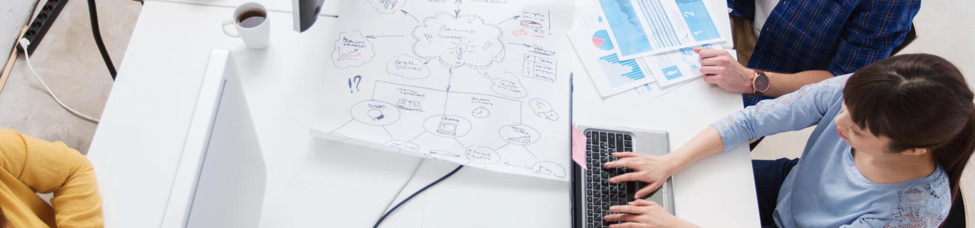 Team arbeitet gemeinsam im Büro an digitalen Anwendungen und Projekten