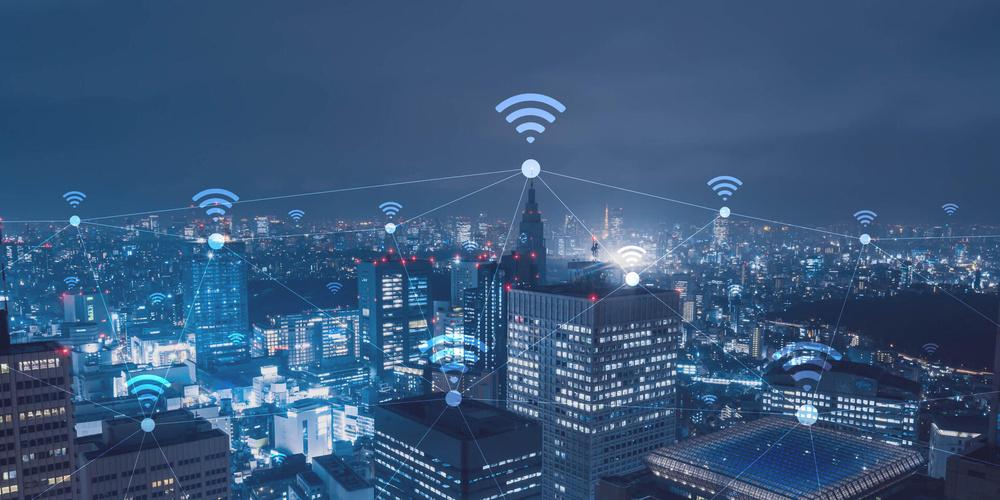 Vernetzte Großstadt bei Nacht mit WLAN-Symbolen