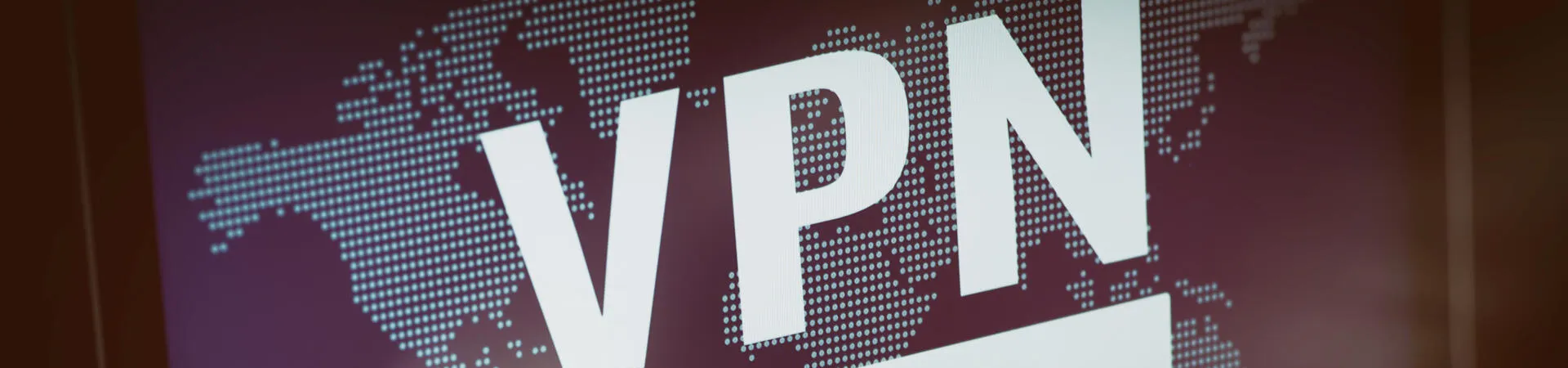 Laptop-Bildschirm mit VPN-Anmeldung vor einer digitalen Weltkarte