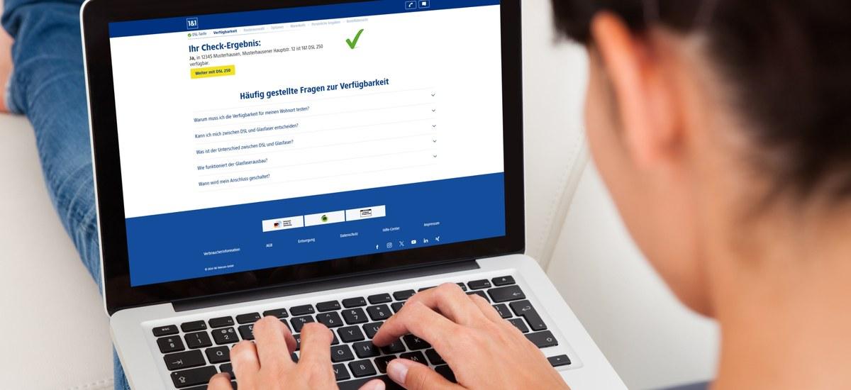 frau sitzt am laptop und macht den eins und eins verfuegbarkeitscheck | 1&1 frau sitzt am laptop und macht den eins und eins verfuegbarkeitscheck