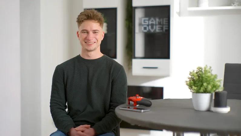 junger mann am tisch mit gamingcontroller